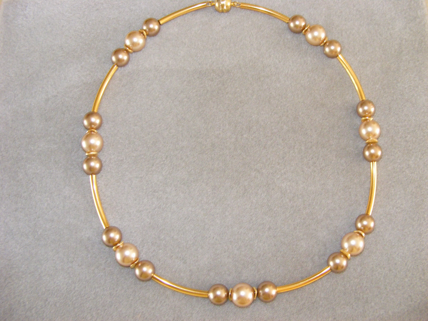 Halskette, Muschelkernperlen in Champagner u.Bronze, 12 u.14 mm, vergold.gebogene Röhrchen